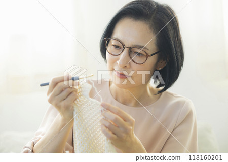 Middle-aged woman knitting in the living room 118160201