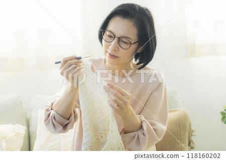 一位中年婦女在客廳織毛衣 一位中年婦女在客廳織毛衣 118160202