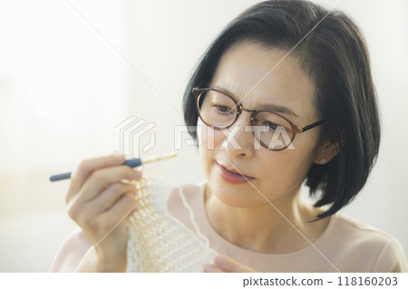 一位中年婦女在客廳織毛衣 118160203