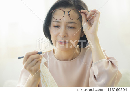 一位中年婦女在客廳織毛衣 一位中年婦女在客廳織毛衣 118160204