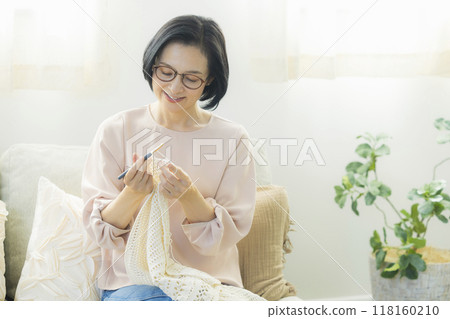 一位中年婦女在客廳織毛衣 118160210