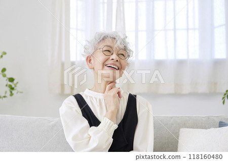 Senior woman imagining in living room Senior woman imagining in living room 118160480