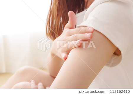 一位女士正在為她的上臂進行皮膚護理 一位女士正在為她的上臂進行皮膚護理 118162410