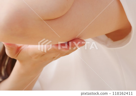 一位女士正在為她的上臂進行皮膚護理 一位女士正在為她的上臂進行皮膚護理 118162411