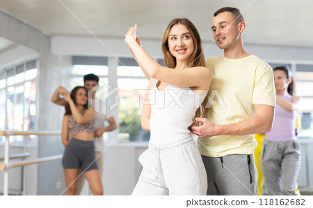 Young man and woman practicing waltz dance in pair in training hall Young man and woman practicing waltz dance in pair in training hall 118162682