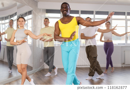 Positive black man participating in group Latin dance class 118162877