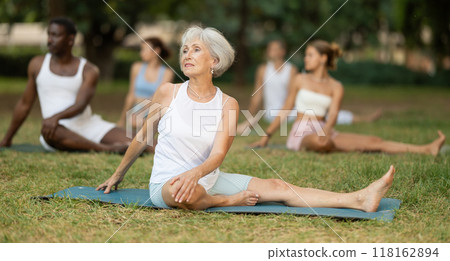 Yoga for people of different ages - elderly woman practicing different yoga poses together in park Yoga for people of different ages - elderly woman practicing different yoga poses together in park 118162894