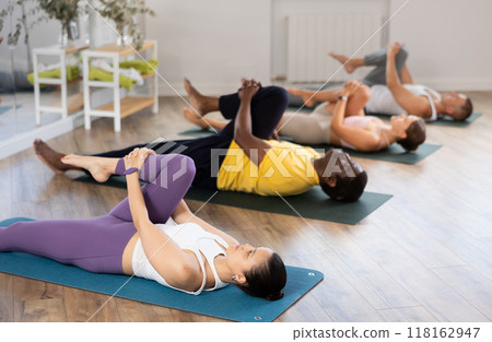 Young woman coach and students perform wind release during training in studio Young woman coach and students perform wind release during training in studio 118162947