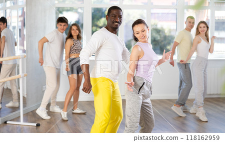Woman enjoying active dances with black male partner in studio Woman enjoying active dances with black male partner in studio 118162959