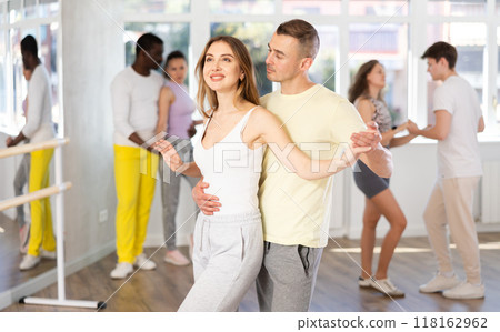 Man and young woman dancing waltz in couple during lesson at studio Man and young woman dancing waltz in couple during lesson at studio 118162962