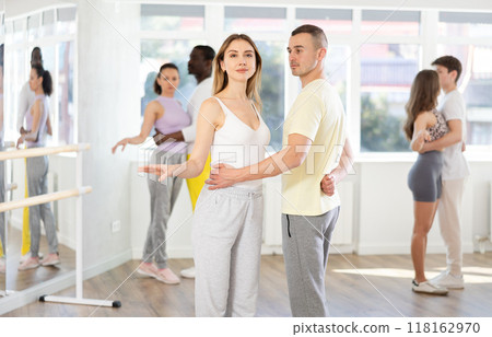 Group of men and women in sportswear learning to dance latin dances in dance studio 118162970