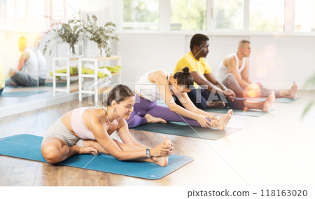 Group of men and women doing yoga in studio 118163020