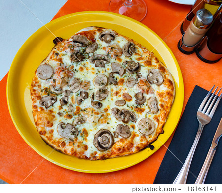 in fast food restaurant freshly baked thin-crust pizza with mushrooms on yellow plate in fast food restaurant freshly baked thin-crust pizza with mushrooms on yellow plate 118163141