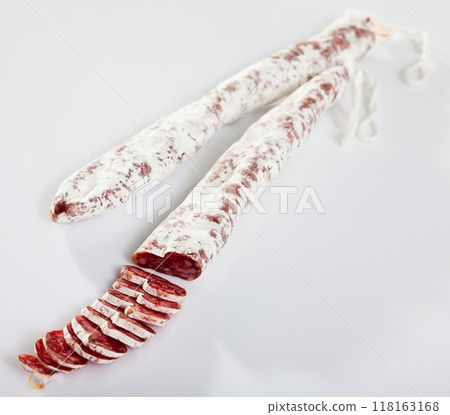 Spanish fuet sausages cut in slices on a white surface Spanish fuet sausages cut in slices on a white surface 118163168