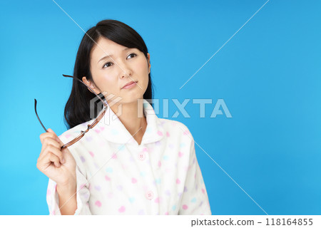 A woman with glasses and a troubled expression A woman with glasses and a troubled expression 118164855