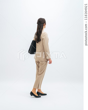Full-body photo of a walking female business person from behind Full-body photo of a walking female business person from behind 118164921