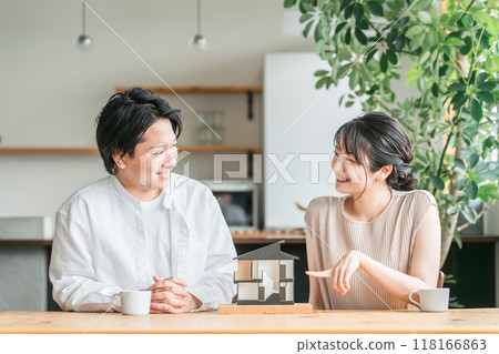 A young couple looking at a house model and considering the floor plan of their home (consultation meeting, house builder, detached house) 118166863