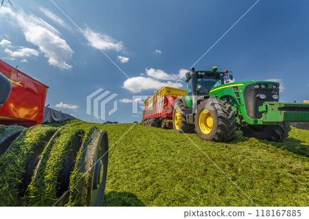 tractor harvesting hay for animals, tractor harvesting green grass for feed, agribusiness concept tractor harvesting hay for animals, tractor harvesting green grass for feed, agribusiness concept 118167885