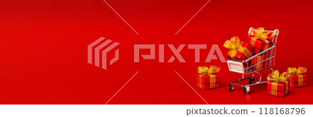 Supermarket trolley, cart with red gifts with gold bows, shopping. The concept of buying gifts for holidays and sales. Sale, discounts, Black Friday. Copy space red background horizontal long banner Supermarket trolley, cart with red gifts with gold bows, shopping. The concept of buying gifts for holidays and sales. Sale, discounts, Black Friday. Copy space red background horizontal long banner 118168796