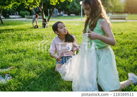 Students on nature walk picking plastic litter, environmental cleanup during outdoor sustainable education class. Concept of experiential learning and ecoliteracy. Students on nature walk picking plastic litter, environmental cleanup during outdoor sustainable education class. Concept of experiential learning and ecoliteracy. 118169511