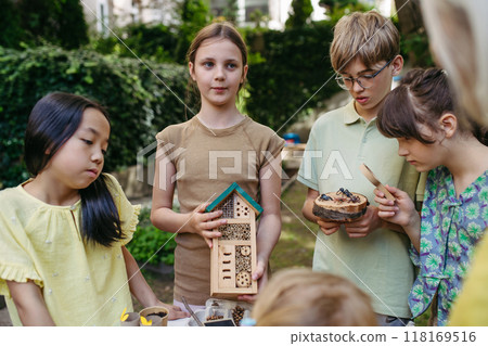 Insect hotel as educational tool for children in outdoor sustainable educational class. Young students learning about insect and biodiversity. 118169516