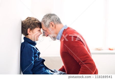 Grandfather spending time with grandson, taking care of him while parents are at work. Touching with foreheads. Grandfather spending time with grandson, taking care of him while parents are at work. Touching with foreheads. 118169541