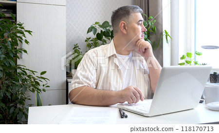 Freelancer Deep in Thought at Desk Looking Out of Window 118170713