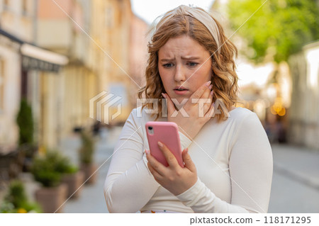 Woman using smartphone typing browsing, loses bad news, fortune loss fail fraud on urban city sunny 118171295