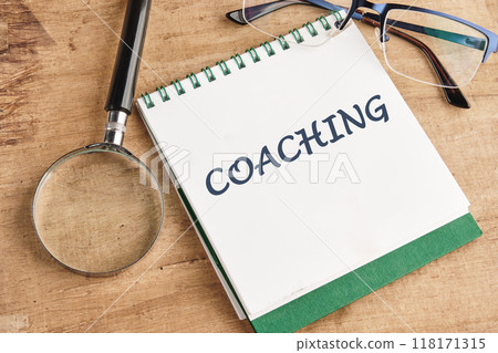 COACHING written in a notebook on a papyrus background, top view 118171315