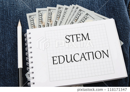 STEM Education. Science Technology Engineering Mathematics. STEM EDUCATION words on a checkered notebook against the background of American paper bills STEM Education. Science Technology Engineering Mathematics. STEM EDUCATION words on a checkered notebook against the background of American paper bills 118171347