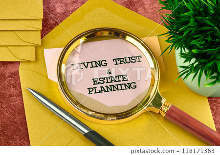 LIVING TRUST and ESTATE PLANNING written on a piece of paper from an envelope through a magnifying glass LIVING TRUST and ESTATE PLANNING written on a piece of paper from an envelope through a magnifying glass 118171363