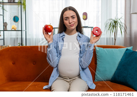 Choosing right nutrition pregnant woman comparing choosing between sweet donut and ripe apple Choosing right nutrition pregnant woman comparing choosing between sweet donut and ripe apple 118171461