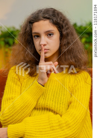 Teenager child girl presses finger to lips makes silence hush sign do not tell gossip secret, quiet 118171894