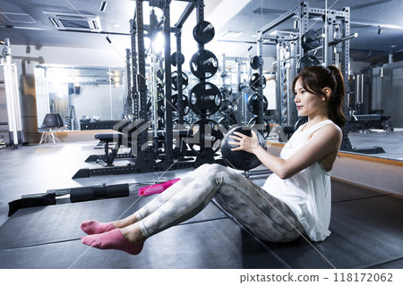 Young woman training at the gym, abdominal muscles, medicine ball 118172062