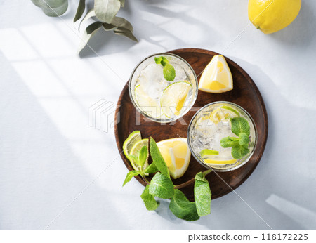 Lemonade drink with fresh lemon, lime, mint and ice. Refreshing citrus mojito cocktail Lemonade drink with fresh lemon, lime, mint and ice. Refreshing citrus mojito cocktail 118172225