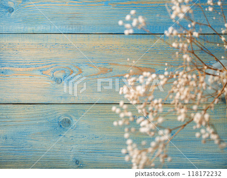 Dry white gypsophila flowers in a glass vase on a blue textured wooden background Dry white gypsophila flowers in a glass vase on a blue textured wooden background 118172232