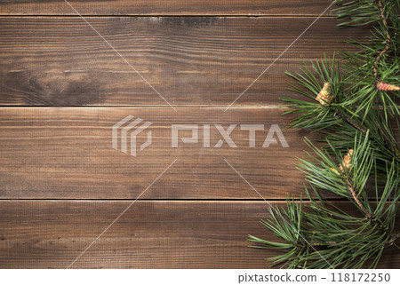 Flat lay of pine branches. Coniferous tree decoration on a brown wooden background. Flat lay of pine branches. Coniferous tree decoration on a brown wooden background. 118172250