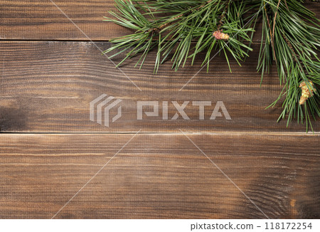 Flat lay of pine branches. Coniferous tree decoration on a brown wooden background. Flat lay of pine branches. Coniferous tree decoration on a brown wooden background. 118172254
