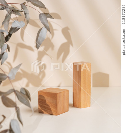 Abstract empty wooden geometric podiums with shadows and leaves on a beige background.  118172255