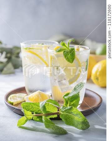 Lemonade drink with fresh lemons, lime, mint and ice. Refreshing citrus mojito cocktail 118172600