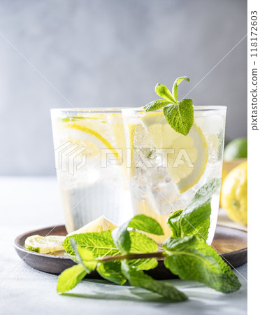 Lemonade drink with fresh lemons, lime, mint and ice. Refreshing citrus mojito cocktail Lemonade drink with fresh lemons, lime, mint and ice. Refreshing citrus mojito cocktail 118172603