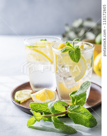 Lemonade drink with fresh lemons, lime, mint and ice. Refreshing citrus mojito cocktail Lemonade drink with fresh lemons, lime, mint and ice. Refreshing citrus mojito cocktail 118172605