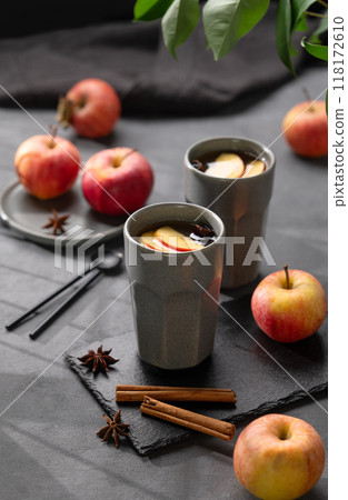 Homemade apple punch or cider with apples and cinnamon in gray cups on a dark background 118172610