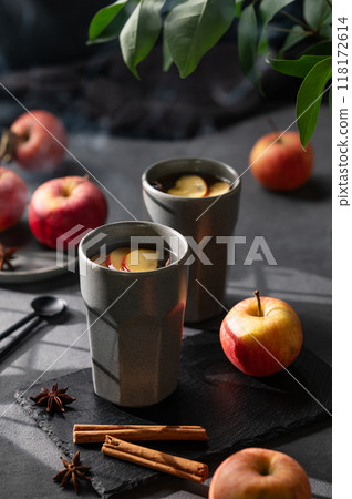 Homemade apple punch or cider with apples and cinnamon in gray cups on a dark background 118172614