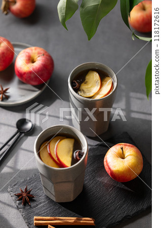 Homemade apple punch or cider with apples and cinnamon in gray cups on a dark background Homemade apple punch or cider with apples and cinnamon in gray cups on a dark background 118172616