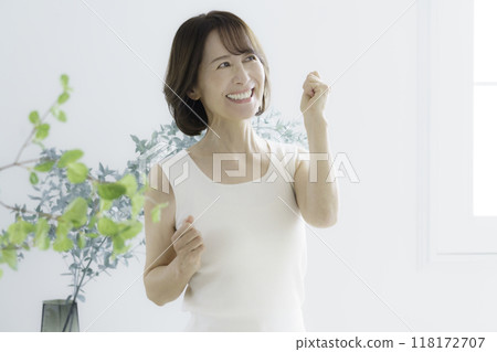 Middle-aged woman stretching indoors Middle-aged woman stretching indoors 118172707