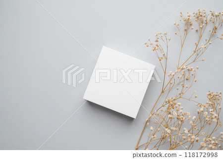 Modern empty product display. Minimal white box with dry flowers on a gray background. Modern empty product display. Minimal white box with dry flowers on a gray background. 118172998