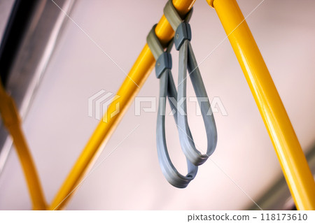 This image shows a close up of a bus handle on a bright yellow pole 118173610