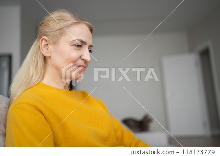 A blonde woman is working with intense focus from her home office, typing on a laptop 118173779