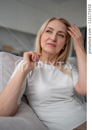 A woman is peacefully lounging on a couch in a contemporary home with simple and clean design 118173938